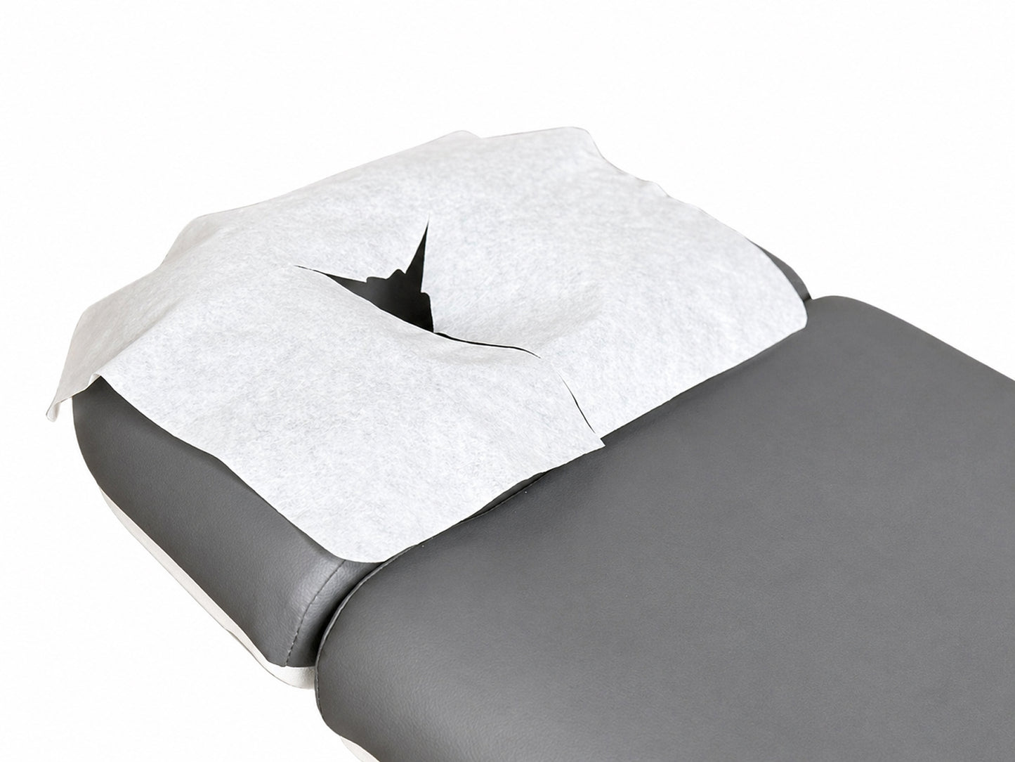 disposable face cradle cover on massage table headrest spa treatment setup