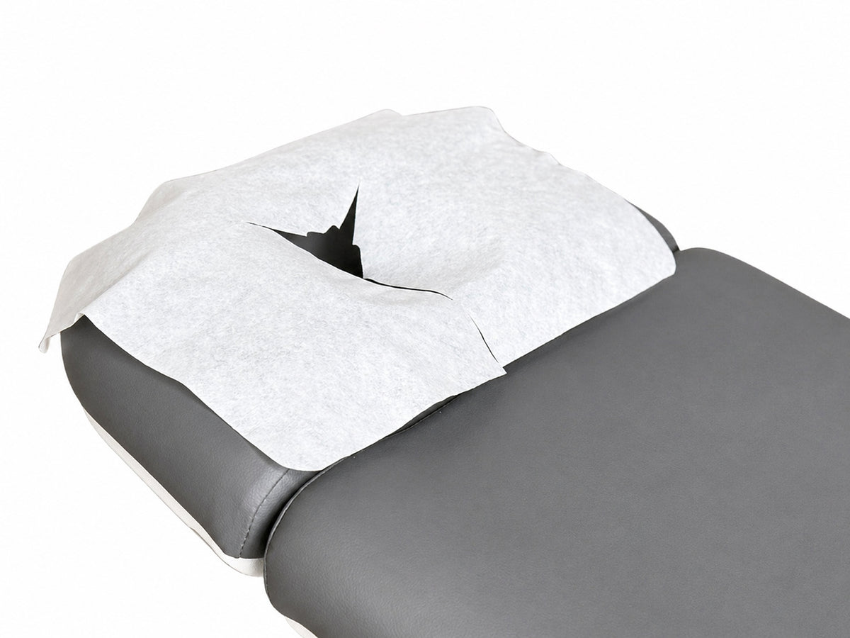 disposable face cradle cover on massage table headrest spa treatment setup