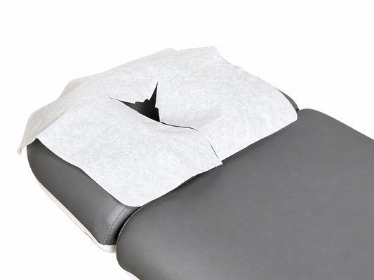 disposable face cradle cover on massage table headrest spa treatment setup