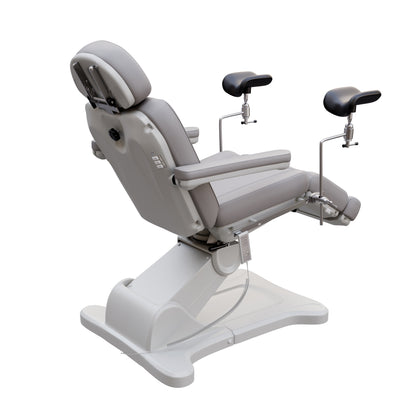 Fully electric Spa Numa OB-GYN swivel treatment chair with removable stainless-steel stirrups, extendable headrest, 240-degree rotation, and PU vinyl upholstery.