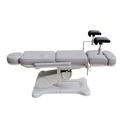 Fully electric Spa Numa OB-GYN swivel treatment chair with removable stainless-steel stirrups, extendable headrest, 240-degree rotation, and PU vinyl upholstery.