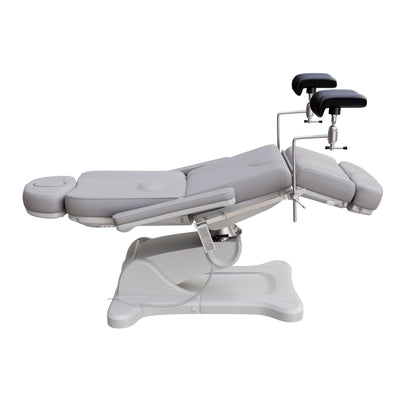 Fully electric Spa Numa OB-GYN swivel treatment chair with removable stainless-steel stirrups, extendable headrest, 240-degree rotation, and PU vinyl upholstery.