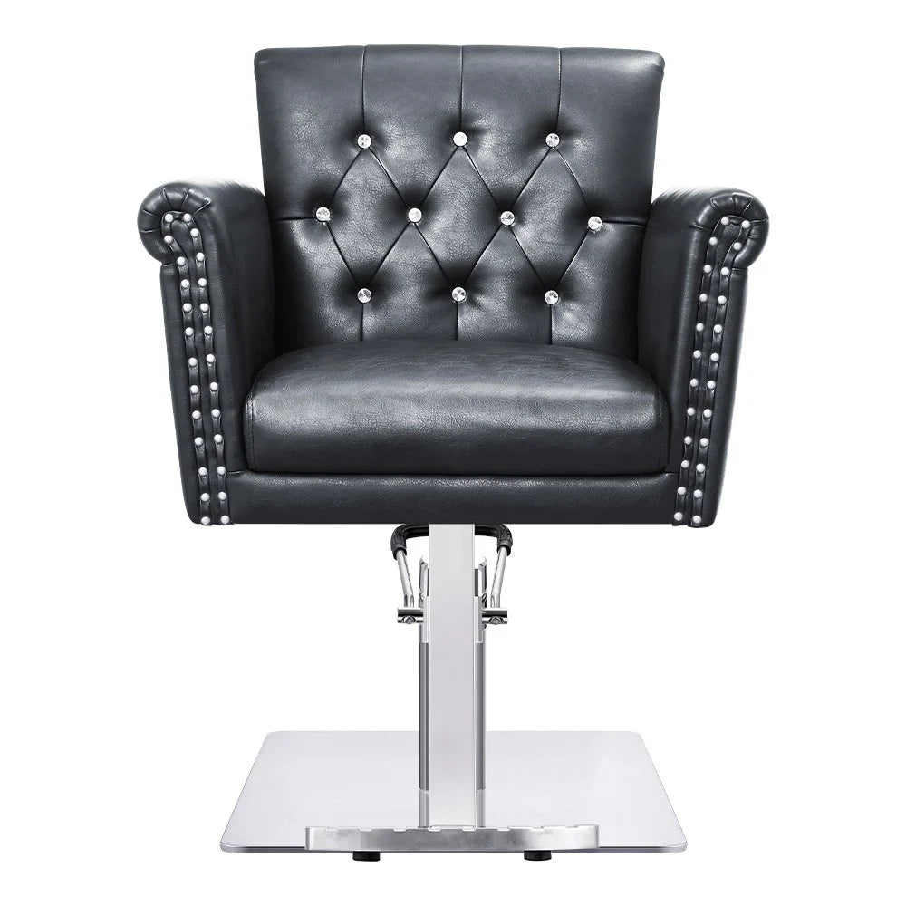 Black leather salon chair with studded details on a white background